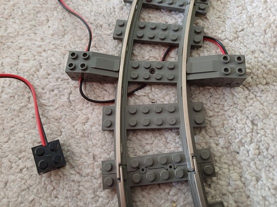 LEGO 9V rail connection cable attached to the tracks with a new cable.