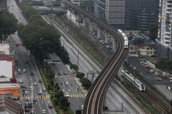 LRT train on elevated rail crossing the at-grade rails and roads. / Photo from linked article.