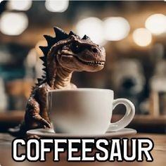 Ein kleiner Dinosaurier sitzt vor einer Kaffeetasse