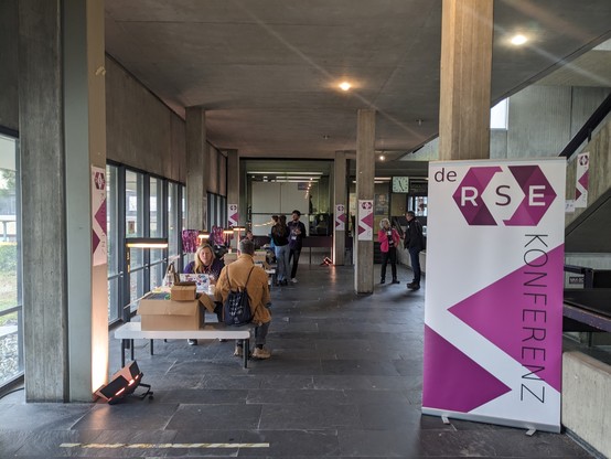 A picture of the registration area with people and a conference roll up