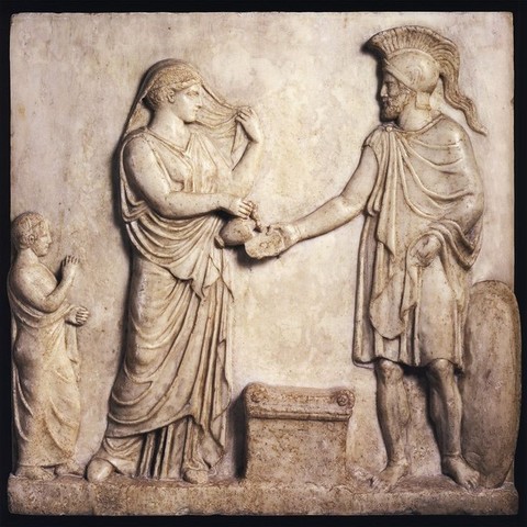 Votive relief of Ares and Aphrodite. She is holding her veil, pouring a libation into the bowl he is holding.