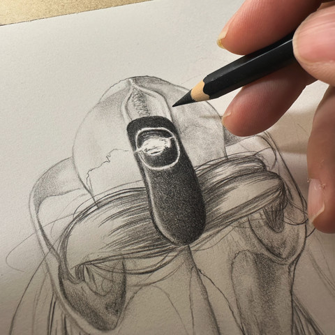 Drawing in progress of a stone sitting on top of a lock of hair and a skull