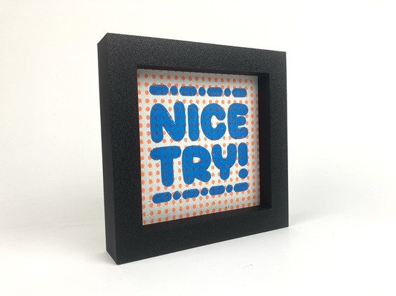 A relief print that says “Nice Try!”