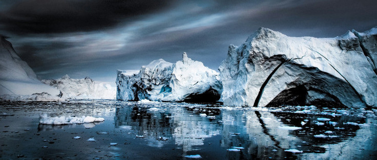 Photo of open water in the Arctic reflecting some icebergs and dark clouds. After recent rapid heating in the Arctic and accelerated melting of Greenland ice, the collapse of the Gulf Stream has become a real possibility. (Photo: Jennifer Latuperisa-Andresen/Unsplash.)