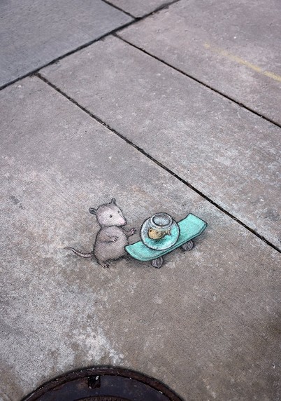 Street Art. Zeichnung auf den Boden.
Ein Possum steht vor einem Surfbrett, auf welchem das Aquarium mit einem Fisch steht.