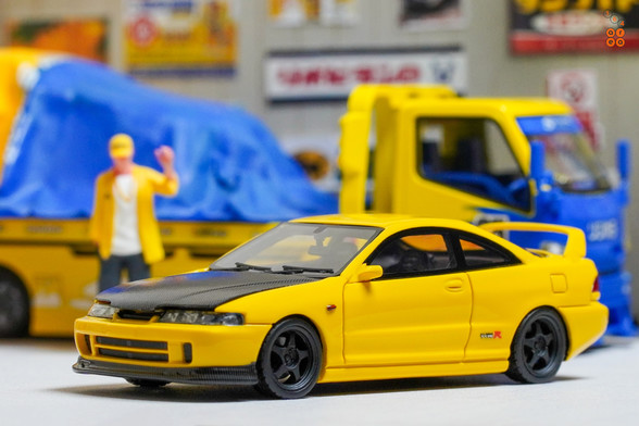 A yellow Honda Integra Type-R DC2 by Nice Auto in 1:64 scale with 1:64 figure on AREA 164