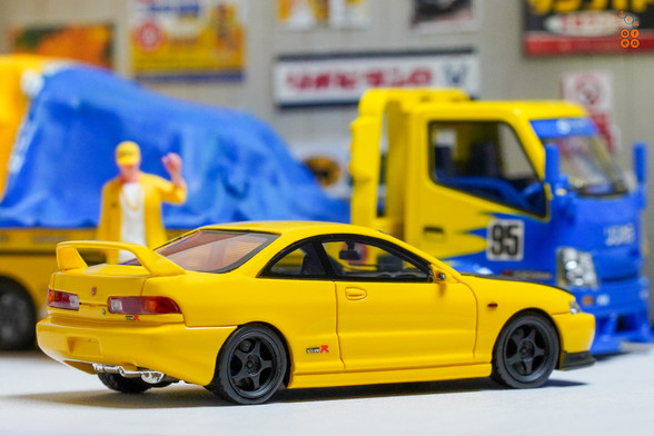 A yellow Honda Integra Type-R DC2 by Nice Auto in 1:64 scale with 1:64 figure on AREA 164