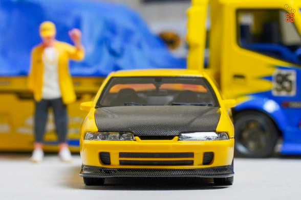 A yellow Honda Integra Type-R DC2 by Nice Auto in 1:64 scale with 1:64 figure on AREA 164