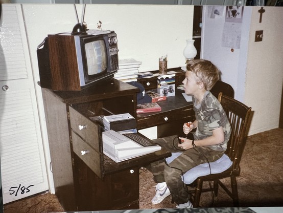 A young driph, clad in camouflage, plays Canyon Climber on the Atari 400. Look how minty fresh white that 400 is! Sitting next to it is an Atari 410 tape drive.

(by this time we'd replaced the little portable tv with a proper television)

Date on the photo is 5/85