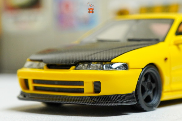 A close-up shot of yellow Honda Integra Type-R DC2 by Nice Auto in 1:64 scale with 1:64 figure on AREA 164