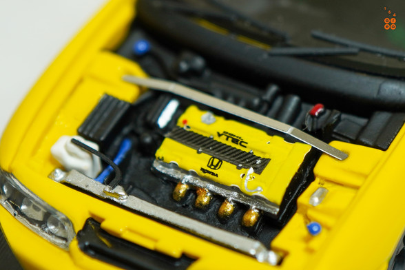 A close-up shot of yellow Honda Integra Type-R DC2 by Nice Auto in 1:64 scale with 1:64 figure on AREA 164