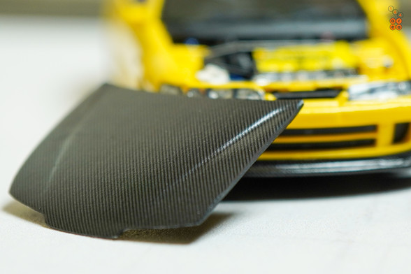A close-up shot of yellow Honda Integra Type-R DC2 by Nice Auto in 1:64 scale with 1:64 figure on AREA 164