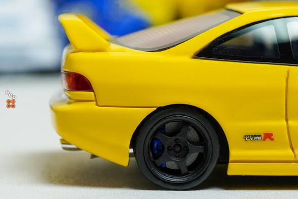 A close-up shot of yellow Honda Integra Type-R DC2 by Nice Auto in 1:64 scale with 1:64 figure on AREA 164