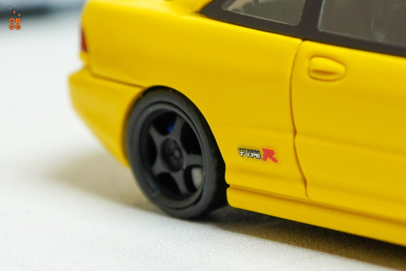 A close-up shot of yellow Honda Integra Type-R DC2 by Nice Auto in 1:64 scale with 1:64 figure on AREA 164