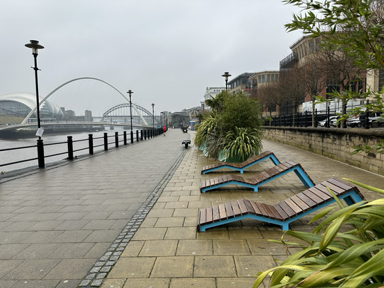 Wet sun loungers on the Newcastle Quayside with the Millennium and Tyne bridges in the background