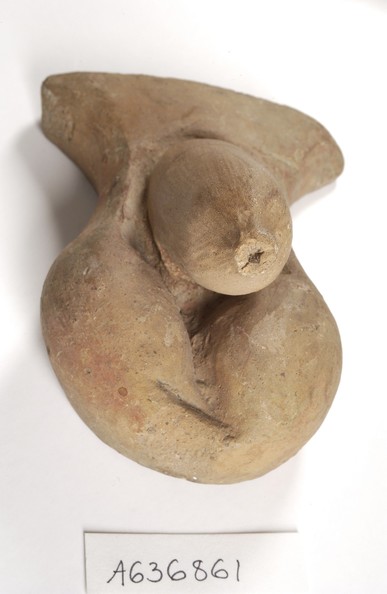 Clay-baked votive offering of a flaccid human phallus and scrotum. The tapered foreskin has broken off.