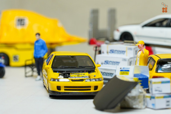 A yellow Honda Integra Type-R DC2 by Nice Auto in 1:64 scale with 1:64 figure on AREA 164
