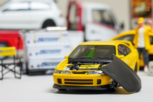 A yellow Honda Integra Type-R DC2 by Nice Auto in 1:64 scale with 1:64 figure on AREA 164