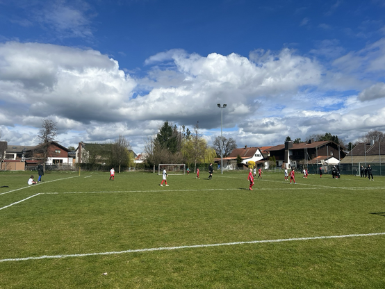 Kinder spielen auf Fußballplatz Fußball in Fußball-Trikots