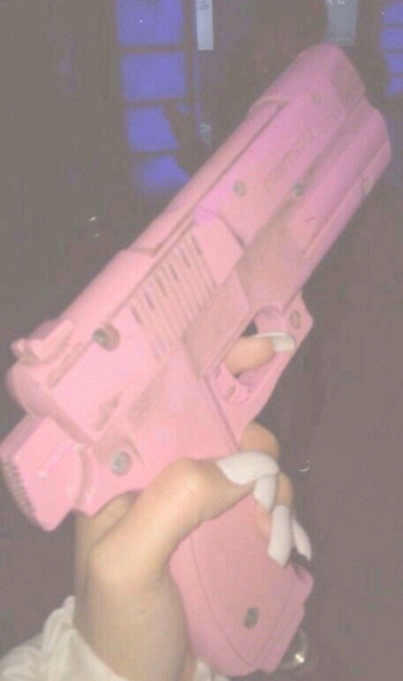 Woman's hand holding a pink gun