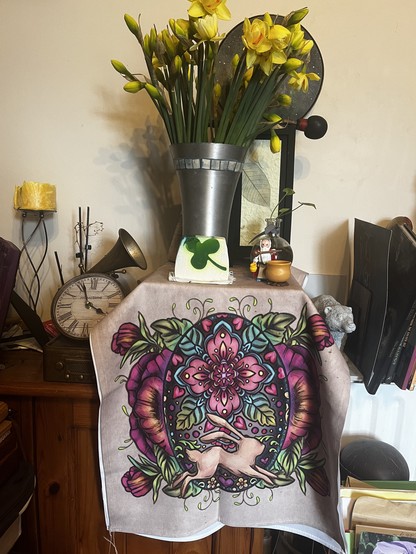 A display of flowers, colourful Spring altar cloth, Miraculix figure and a bar ofAlban Eilir (Spring Equinox soap) 