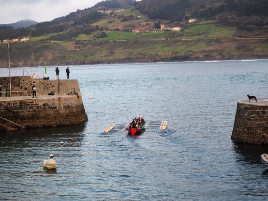 Trece remeros y el patrón de una trainera saliendo del embarcadero de Mundaka