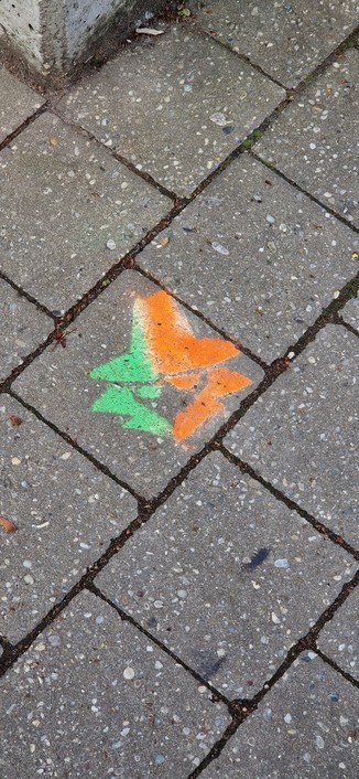 Graphische Darstellung eines Agent, mit Farbe auf den Gehweg gesprueht