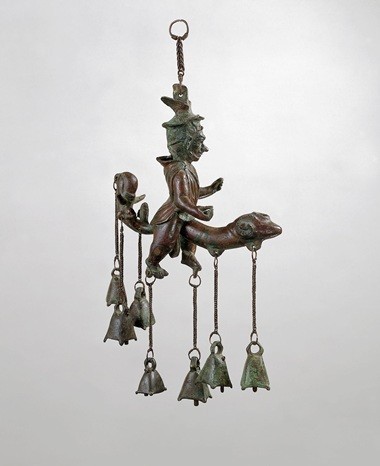 Roman bronze windchime depicting a man with a giant erection. Seven bells hang down from the figure in total, two from the phallus, two from the man's feet, and three from a tail-like structure in his rear.