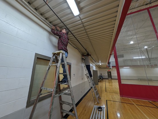 Workers installing cabling in gym