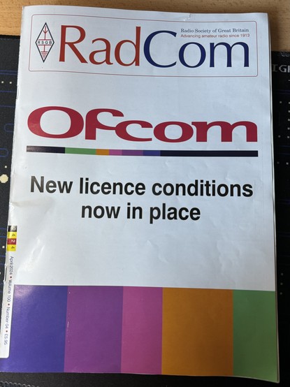 The front cover of RadCom with the lozenge shaped RSGB at the top left which consists of a representation of an antenna above the letters RSGB and with a representation of the earth symbol below. The cover of this issue is white with the words 'OFCOM new licence conditions now in place' as the banner subject.