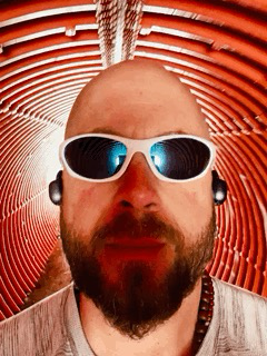 GIF walking down an orange tunnel wearing sunnies