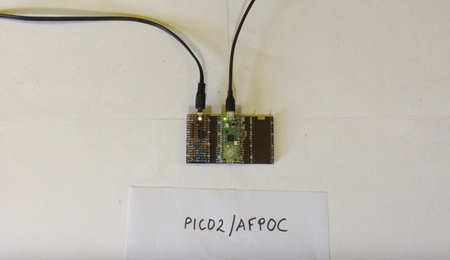 Photo of a Raspberry Pi Pico on a Pimoroni dual expander with a home-made resistor, passive mixer board plugged in.

Underneath the pico is a hand-written sign saying "PICO2/AFPOC".