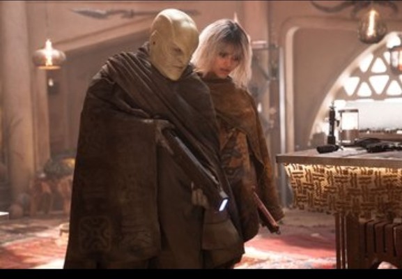 Two aliens in dirty-looking cloaks look down at the ground. They are holding phaser rifles and prepared to shoot at someone unseen beneath the image.