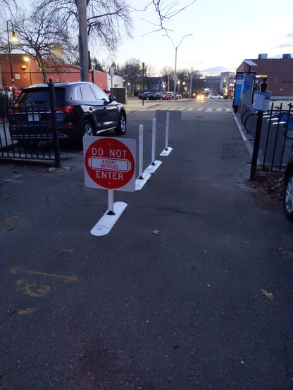 View from the other side of the removed gate, replaced with flex posts in the middle of the lane and, Do Not Enter, signs with smaller, Except Bicycles, stickers in the middle.