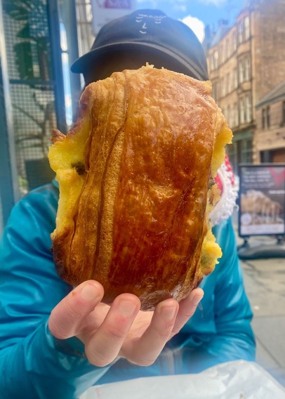Person holding a pain suisse in front of their face to show that it is head-sized
