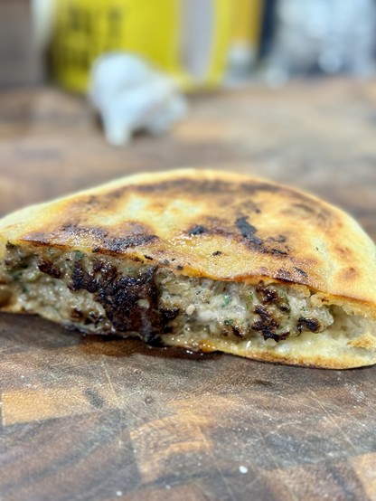 Arayes (Arabic bread stuffed with kefta and cooked in a pan) resting on a cutting board