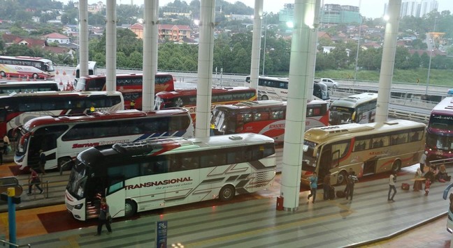 Various express buses at arrival platforms dropping passengers with other express buses queuing behind the platform. / Photo from linked article.
