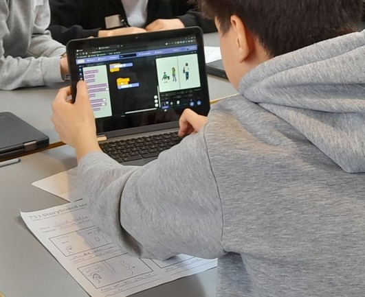 A boy working on the computer using Scratch