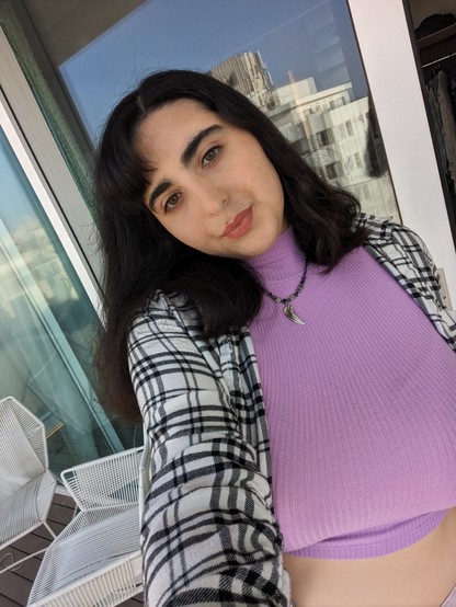 Photo of me in pink top with black and white flannel and handmade silver feather pendant beaded silver arrows necklace
I have midi dark brown hair pink lips and green eyes