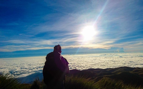 Hiker watching the sunrise at Mount Pulag