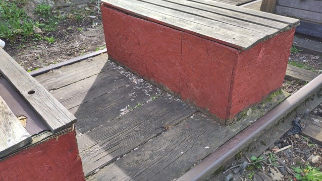 Wooden DIY benches at the open air area. Part of the Waggon concert venue. Covered on fresh red paint.