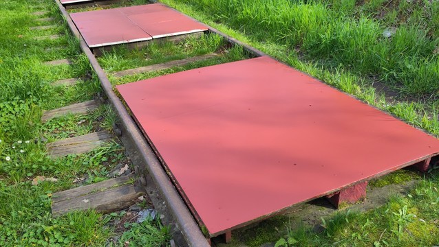 Wooden platform on the rails. Part of the Waggon concert venue. Covered on fresh red paint.