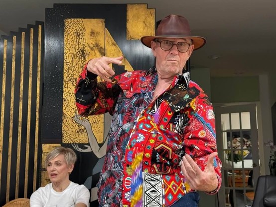 Yuri Dojc striking a pose, wearing a colorful shirt and cowboy hat.