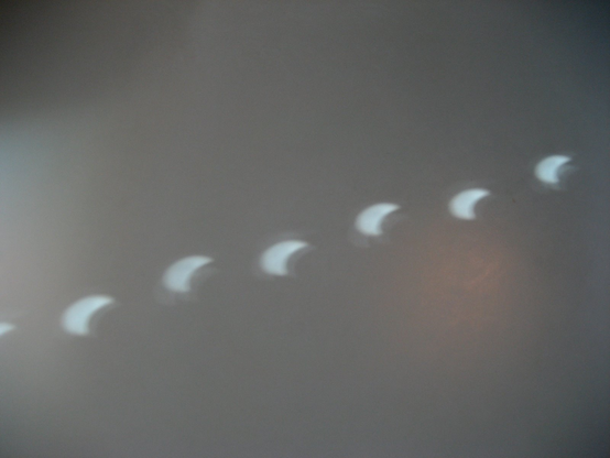 Partially eclipsed sun shining through small holes in a window blind and onto a desktop, and creating a crescent shaped light spot. (Oslo, Aug 1st, 2008)