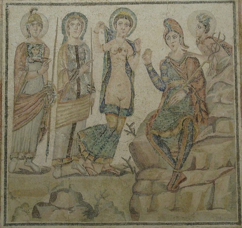 Mosaic depicting the Judgement of Paris. Paris is sittig on a rock, holding the golden apple in his hand and a shepherd's crook in the other. Aphrodite is dropping her robes for him, appearing in the nude with a slit depicted on her bared vulva. Behind Aphrodite, Hera and Athena stand fully clothed. Hermes observes the scene from behind the rock.