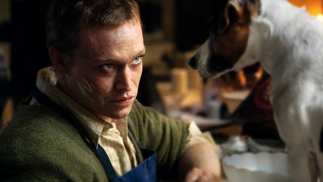 Caleb Landry Jones schaut einem Jack Russell Terrier tief in die Augen