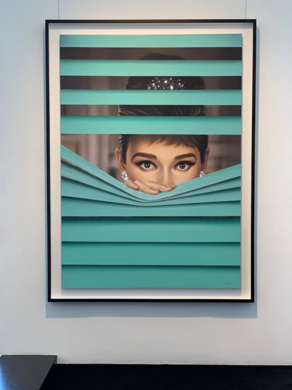 a painting, it is framed on a white wall background, it is of audrey hepburn , she is peeking through teal-colored window blinds, looking at the viewer, the lower half of her face covered by the blinds, her fingers pressing them down, she is wearing a jeweled tiara-type accessory on her hair tied up on her head, she looks at the viewer with her large brown eyes, she wears large diamond earrings 