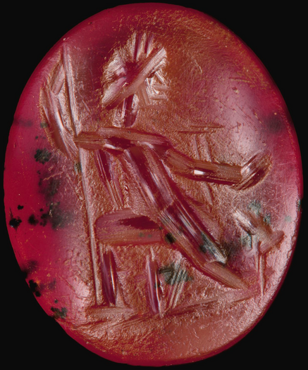 Roman cornelian intaglio of Jupiter, enthroned, and facing left, wearing a wreath. He holds a spear or sceptre vertically in his left hand behind him, and his right hand is outstretched before; beneath this hand, on the ground, stands an eagle facing the god. The intaglio has heavy surface wear.