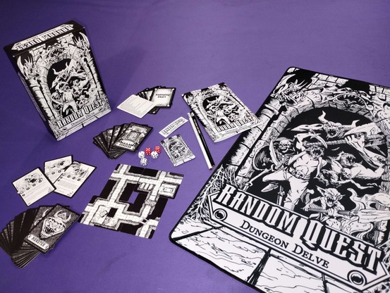 various Random Quest products splayed out including gaming mat, pencil, sticker, magnet and the game itself. 