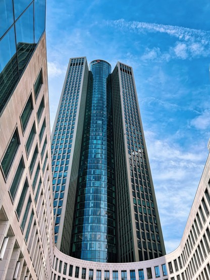 Foto eines Hochhausturms in Frankfurt, Blickrichtung von unten nach oben in den blauen Himmel an der Fassade und Fensterfront entlang